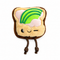 Juguete de peluche para perros marca Verný con forma de tostada animada. Tiene una cara sonriente que guiña un ojo, detalles de cobertura de mantequilla y rebanadas de aguacate en la parte superior, y dos patas colgantes de cuerda marrón